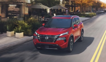Nissan Rogue driving on a city street showcasing engine performance