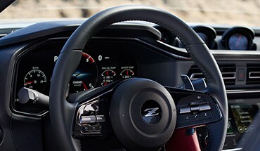 2023 Nissan Z view of cockpit with steering wheel, dashboard, gauge cluster, and touch-screen.