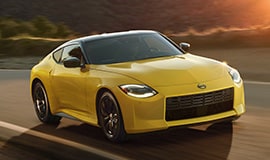 2023 Nissan Z in yellow on a rural road.