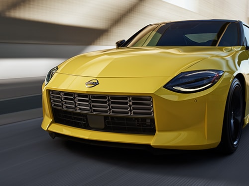 Angled front view of a yellow 2024 Nissan Z driving fast