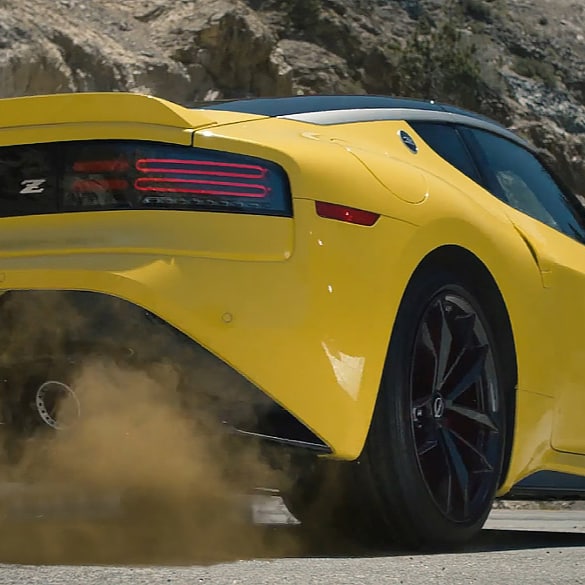 Angled rear view of a yellow 2024 Nissan Z kicking up dust