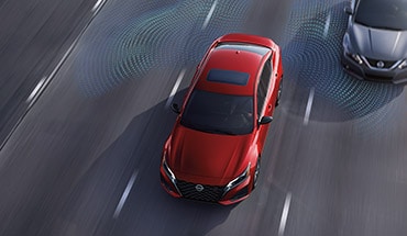 2023 Nissan Altima on highway showing blind spot warning technology.