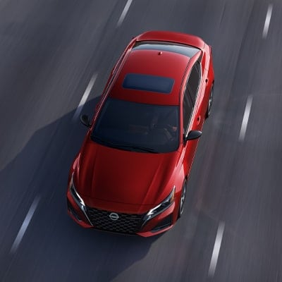 Angled top view of a red 2024 Nissan Altima driving