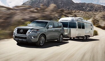 2022 Nissan Armada towing an airstream on mountain road.