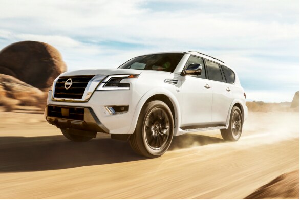 2023 Nissan Armada driving down a dusty desert road.