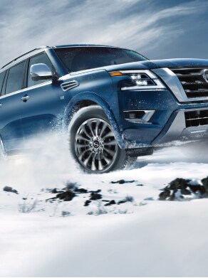2023 Nissan Armada driving on a snowy mountain