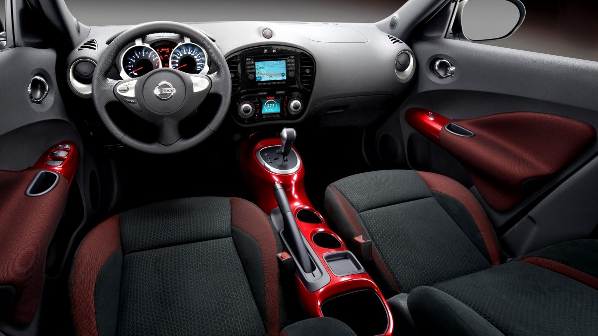 The interior of the Nissan JUKE crossover with red trim accents