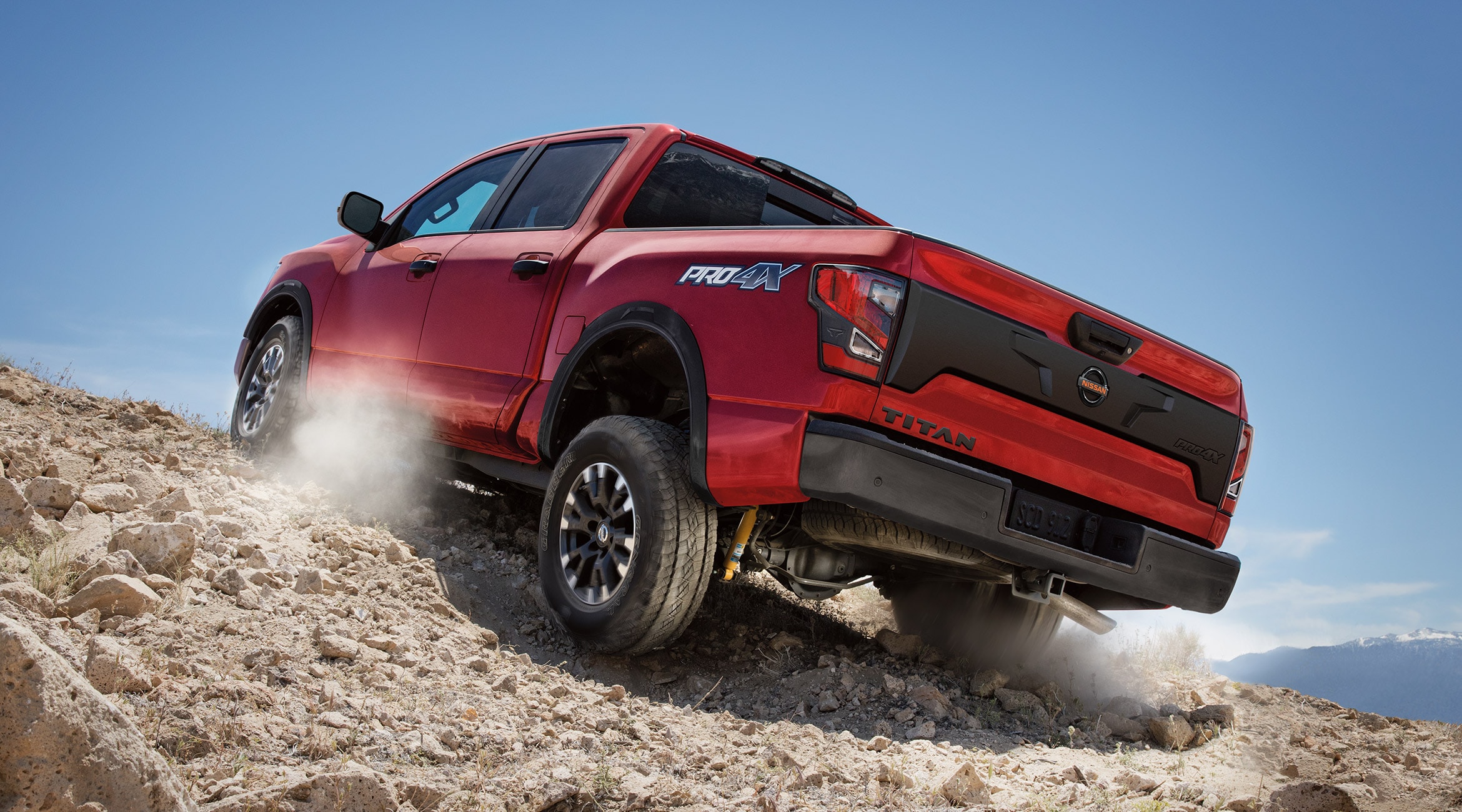 A red Nissan Titan Truck going uphill showcasing its off-road capabilities
