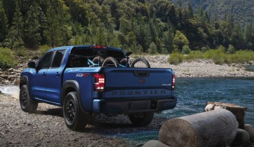 2023 Nissan Frontier off-road near a lake, with bicycles in the bed