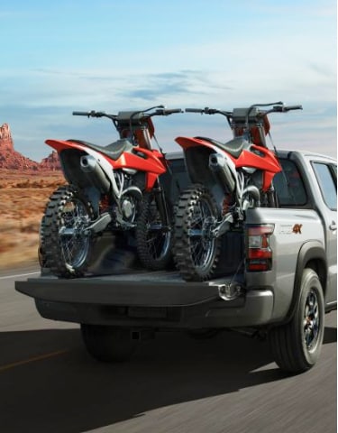 2024 Nissan Frontier with two bikes in the bed driving