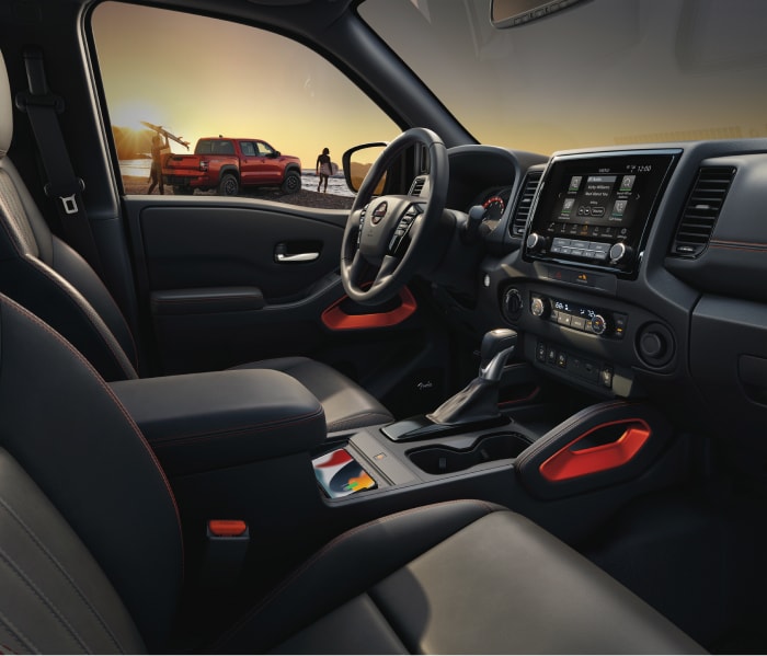 2024 Nissan Frontier Crew Cab front seat with a view of a red Frontier out the driver window