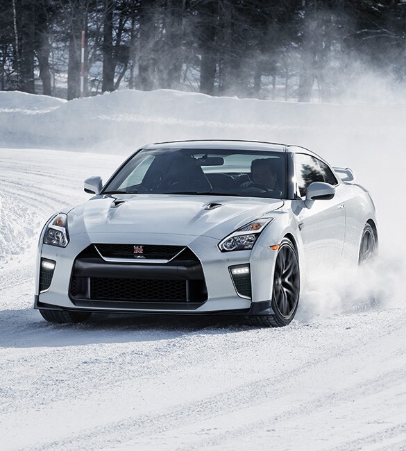 Nissan GT-R driving around a curve in the snow.