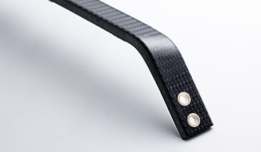 Nissan GT-R closeup of a suspension strut bar made of carbon fiber.