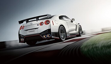 2023 Nissan GT-R with spoiler driving on a racetrack.