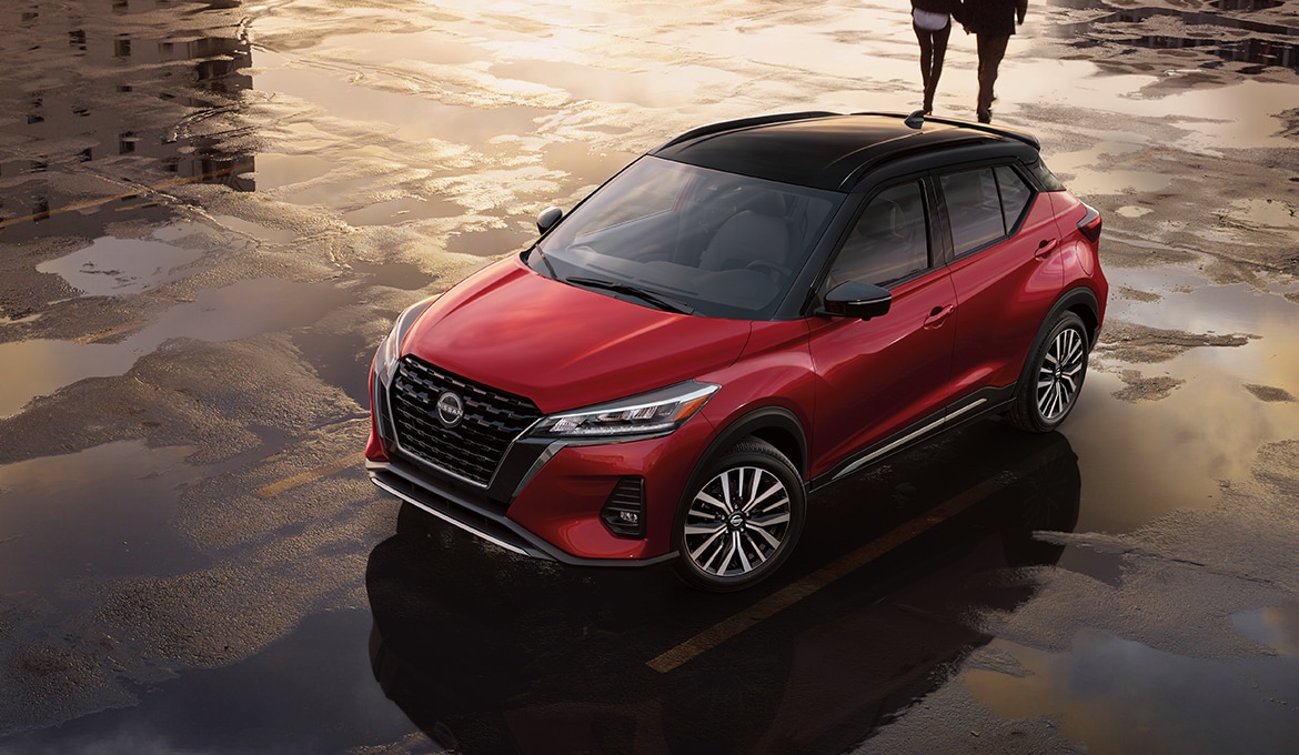 Red 2024 Nissan Kicks parked in wet parking lot