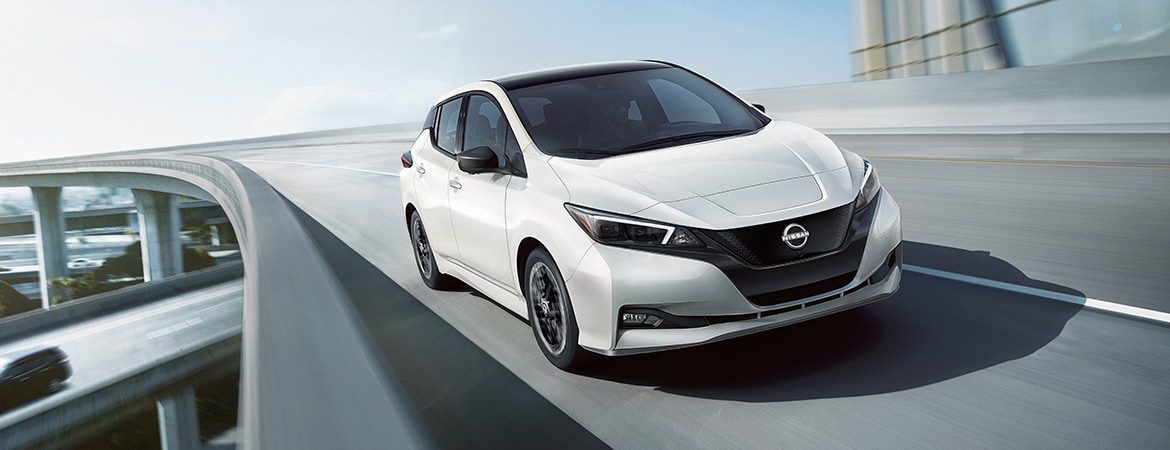 2024 Nissan LEAF in white driving across overpass
