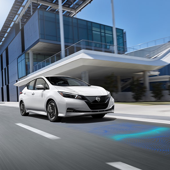 2025 Nissan LEAF driving through the city street showcasing intelligent forward collission warning system