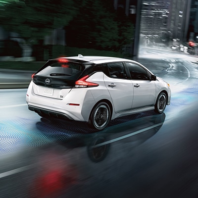 2025 Nissan LEAF driving on the city street showcasing e-pedal feature