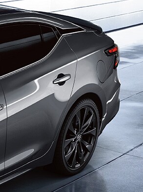 2023 Nissan Maxima highlighting Sunset Drift ChromeFlair exterior color in a parking garage.