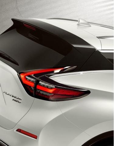 Angled rear view of a silver 2024 Nissan Murano featuring the rear spoiler