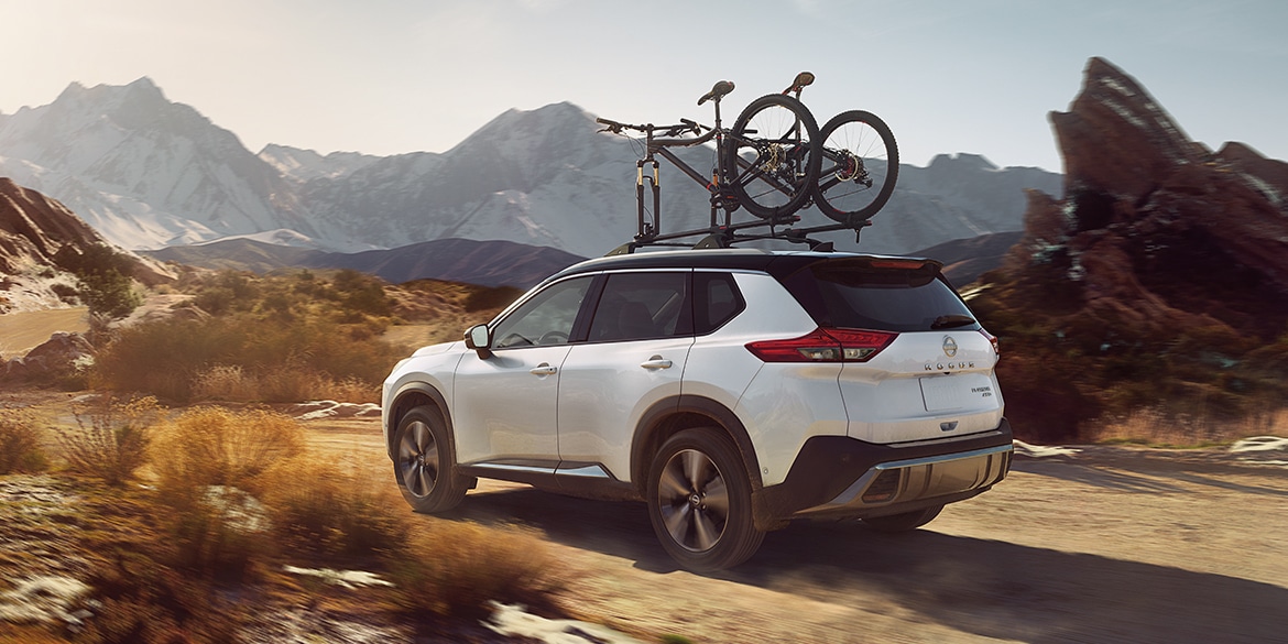 2023 Nissan Rogue illustrating intelligent All-Wheel Drive in the mountains with bikes on roof rack.