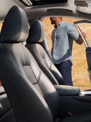 2022 Nissan Sentra seen premium interior from the passenger side with people about to get in driver's side front and rear