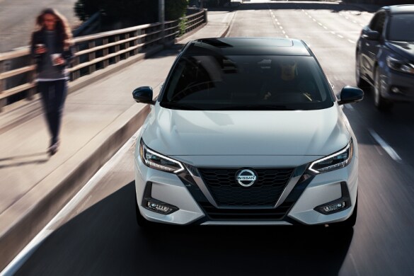2023 Nissan Sentra front view in white driving through city streets