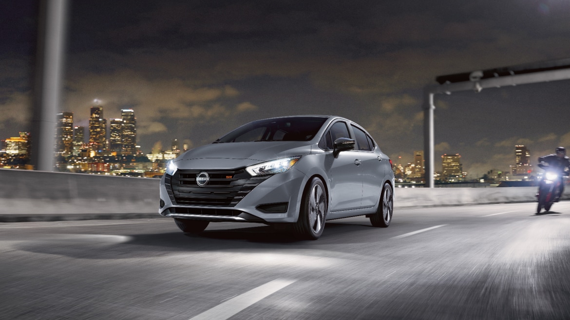 2024 Nissan Versa in grey driving on highway at night