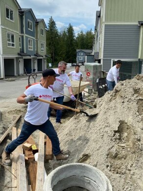 Nissan volunteers at Habitat for Humanity shovelling sand