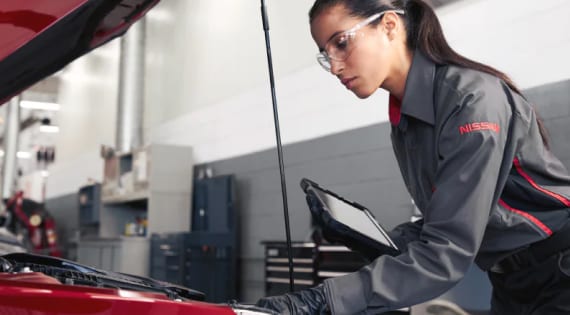 Nissan mechanic checking vehicle engine