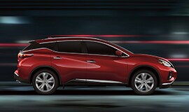 2023 Nissan Murano shown in profile driving down a street at night illustrating performance.