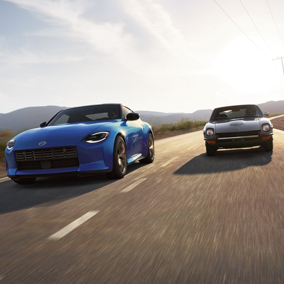 A blue 2024 Nissan Z driving fast beside another grey vehicle