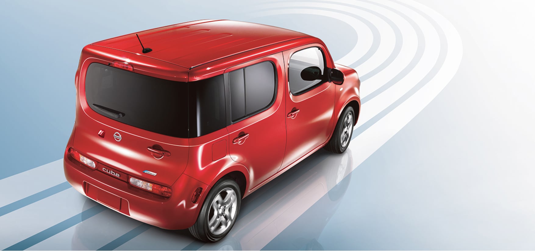 Red Nissan Cube driving on blue background to demonstrate fuel economy