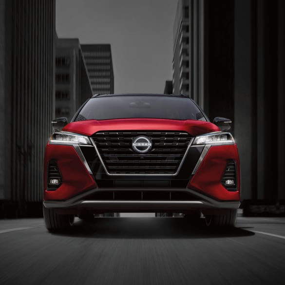 Front view of 2024 Nissan Kicks in red driving down street